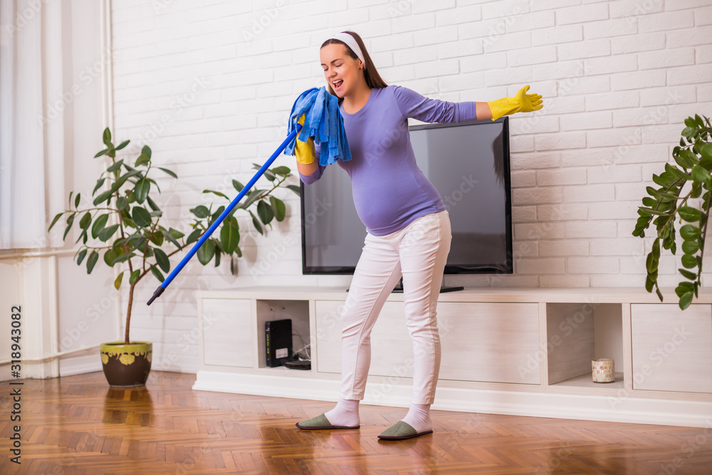 Beautiful pregnant woman enjoys cleaning her house. Beautiful pregnant woman enjoys cleaning her house.
