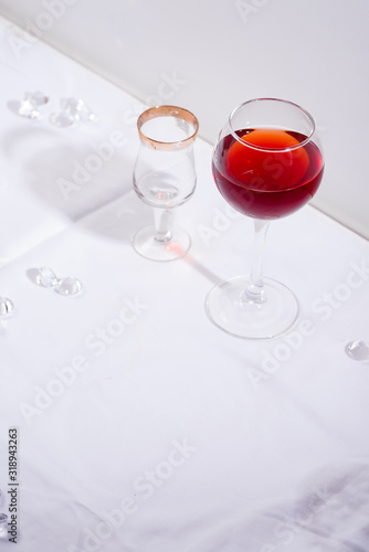 red wine in a wineglass with shadows isolated on white textile background