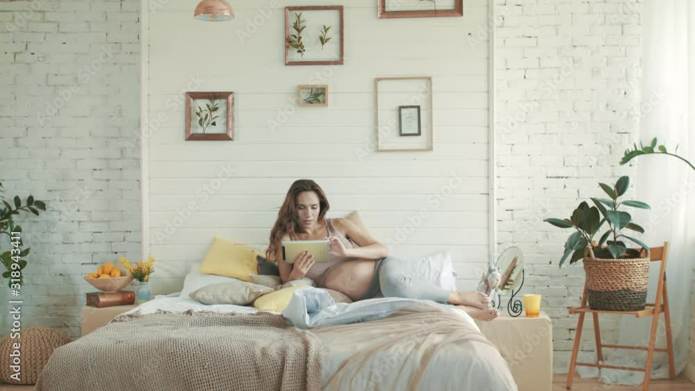 Pregnant woma using laptop at home. Happy pregnant belly mother surfing internet Pregnant woma using laptop at home. Happy pregnant belly mother surfing internet