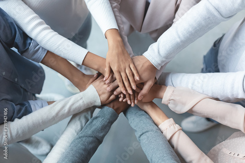 Multiracial business team putting hands on top of each other photo