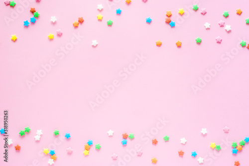 Tablou pe pânză Colored sugar stars sprinkled on a pastel light pink backdrop