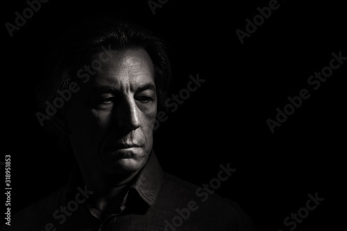 Portrait of a stern man on a black background with space for text.
