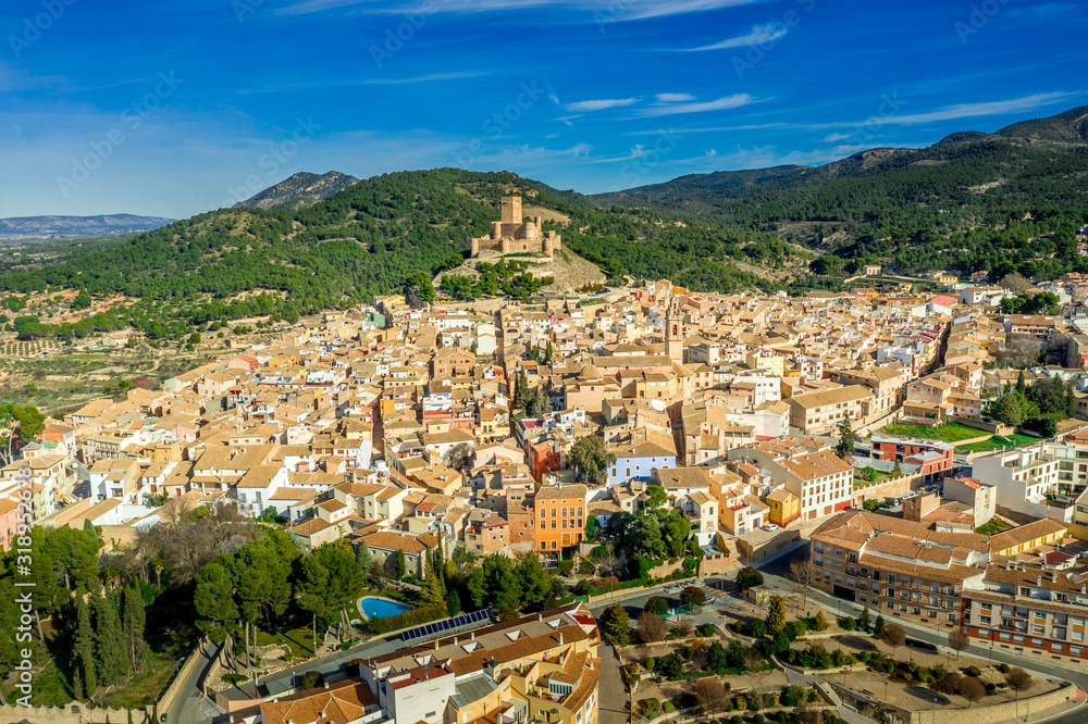 Fototapeta premium Aerial view of Biar castle in Valencia province Spain with donjon towering over the town and concentric walls reinforced with semi circular towers on a sunny day with blue sky