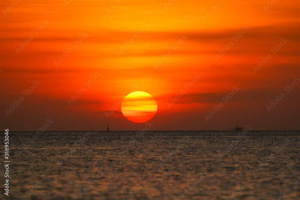 Fishing boat in the ocean on a sunset background