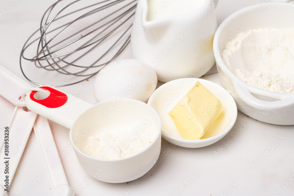 organic products milk, flour, eggs and butter on a white background organic products milk, flour, eggs and butter on a white background