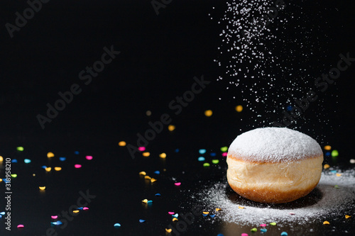 German Doughnut with confetti infront of a black background