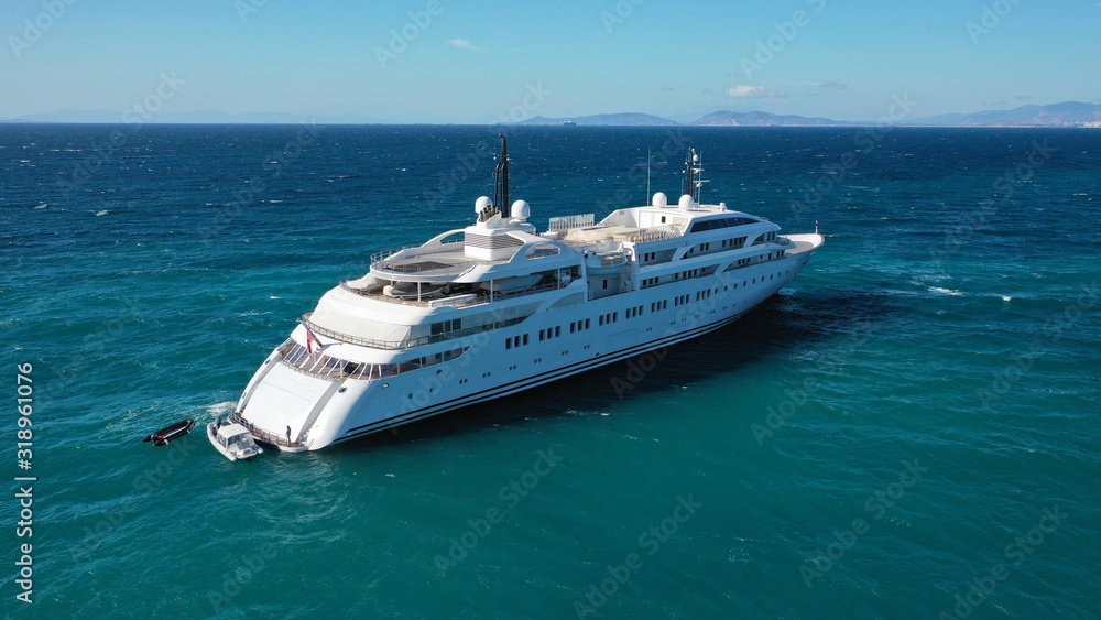 Aerial drone top down photo of luxury yacht docked in Mediterranean destination port with deep blue sea