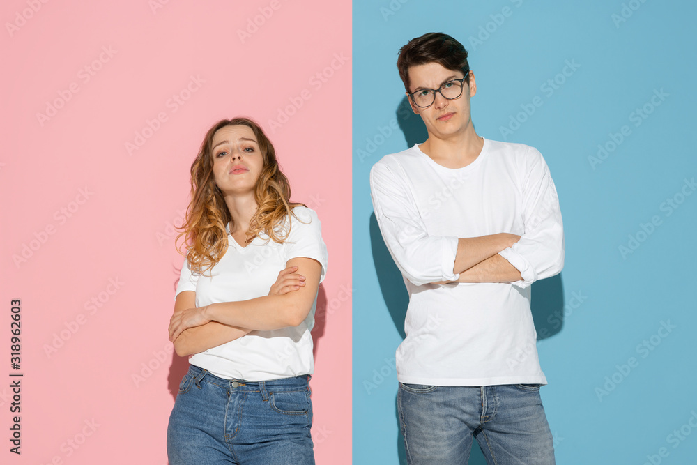 Standing with hands crossed. Young and happy man and woman in casual clothes on pink, blue bicolored background. Concept of human emotions, facial expession, relations, ad. Beautiful caucasian couple. Standing with hands crossed. Young and happy man and woman in casual clothes on pink, blue bicolored background. Concept of human emotions, facial expession, relations, ad. Beautiful caucasian couple.