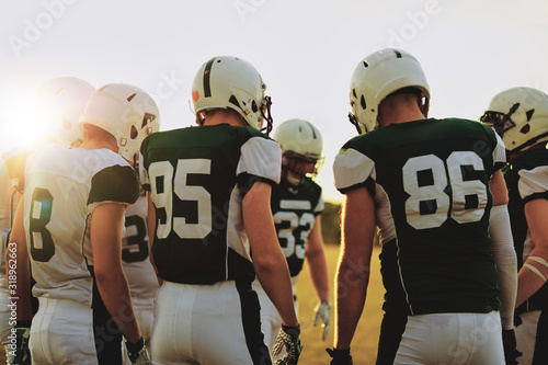 Canvas Print American football players standing in a huddle before a game