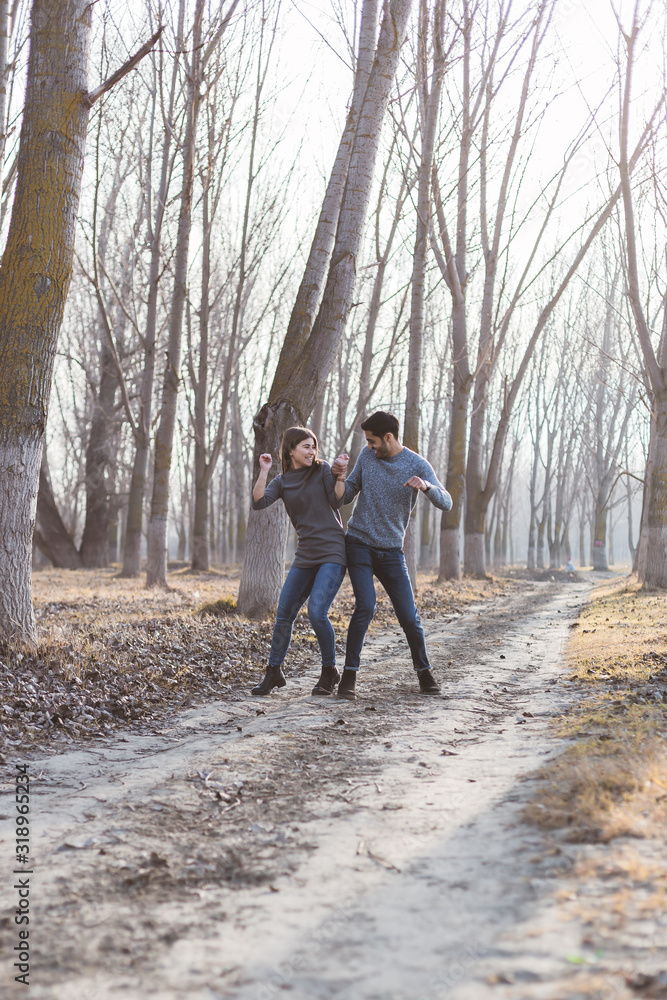 Young couple playing in the woods in the autumn season