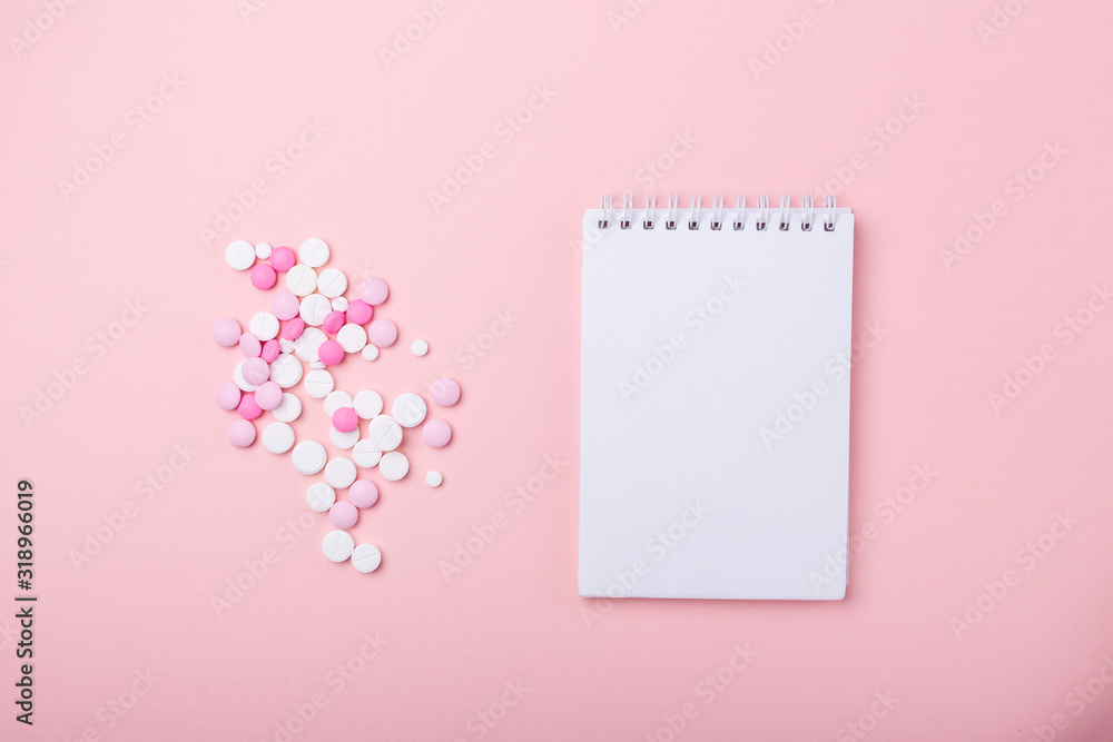 Pink and white pills on pink background Notebook Heap of assorted various medicine tablets and pills. Pink and white pills on pink background Notebook Heap of assorted various medicine tablets and pills.