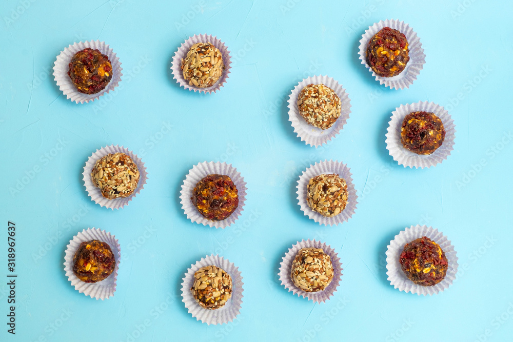 Various energy balls made of dried dates and nuts on soft blue background. Various energy balls made of dried dates and nuts on soft blue background.