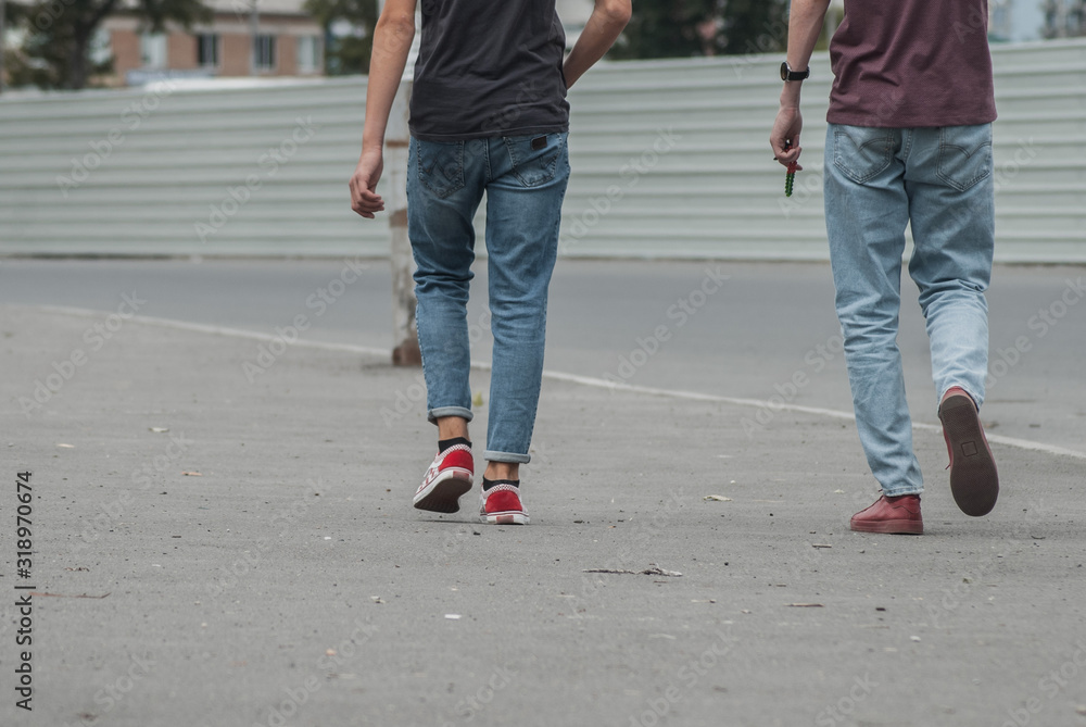 young men in jeans and sneakers walking down the street, young men in jeans and sneakers walking down the street,