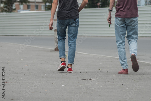 young men in jeans and sneakers walking down the street,