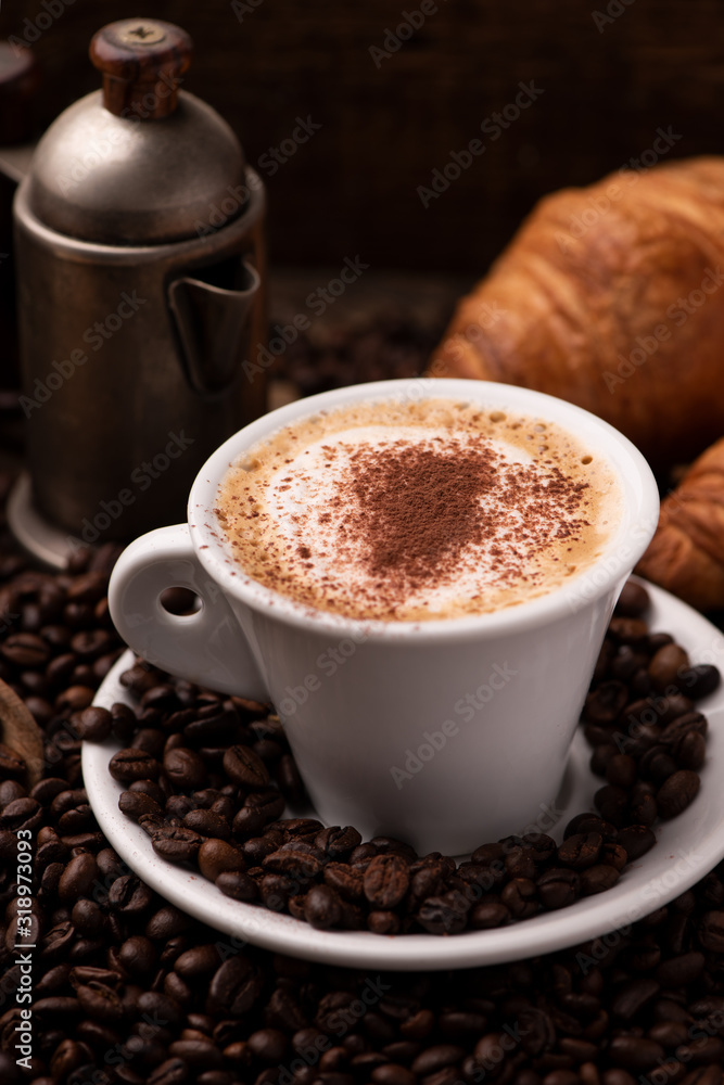 Cappuccino and croissant with coffee beans close up Cappuccino and croissant with coffee beans close up