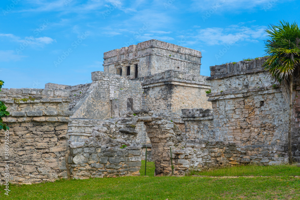 Ruins of ancient Tulum. Architecture of ancient maya. View with temple and other old buildings, houses. Blue sky and lush greenery of nature. travel photo. Wallpaper or background. Yucatan. Mexico. Ruins of ancient Tulum. Architecture of ancient maya. View with temple and other old buildings, houses. Blue sky and lush greenery of nature. travel photo. Wallpaper or background. Yucatan. Mexico.