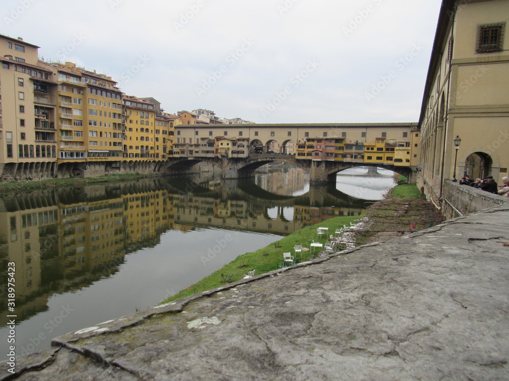 View of the Ponte Vecchio and its reflection on the Arno River in Florence, Italy 