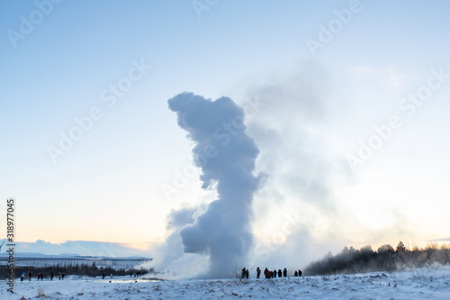 An erupting soaring geyser in the Valley of Geysers. Magnificent Iceland in the winter.