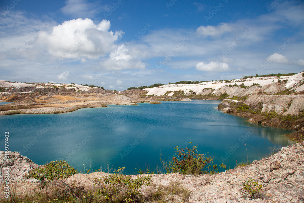 Turquoise beautiful lake formed after mining bauxite in subtropical forests on a clear Sunny day. Nature, ecology, and environmental protection.