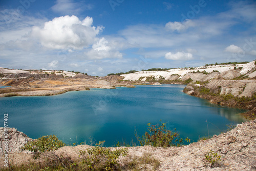 Turquoise beautiful lake formed after mining bauxite in subtropical forests on a clear Sunny day. Nature, ecology, and environmental protection.