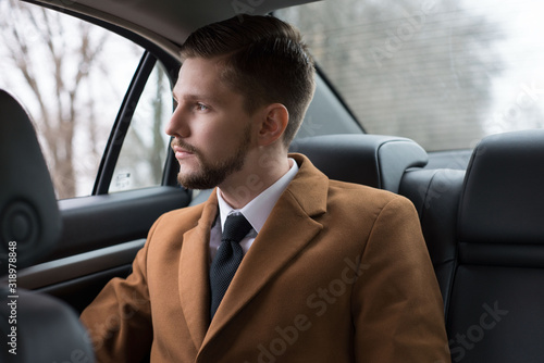portrait of a young guy with a beard. Businessman in a car in the passenger seat rides to the office, to work © Алексей Доненко