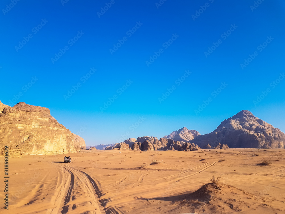 Sunset safari at the Wadi Rum desert, Jordan. Pick up truck tour with bedouins. Car rides on the sand in the middle of two rocky mountains at the famous desert. 
