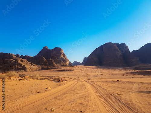 Safari trip on pick-up trucks. Tire tracks on the sand. Nature park and reserve in Jordan. Scenic landscapes at the Wadi Rum desert. 