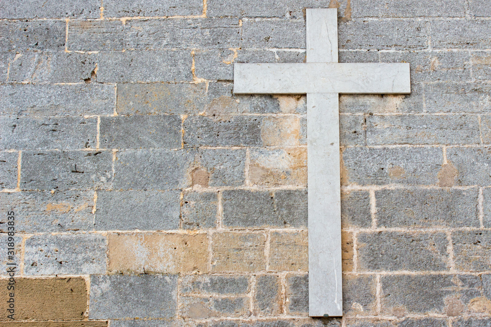 Christian cross on a stone wall
