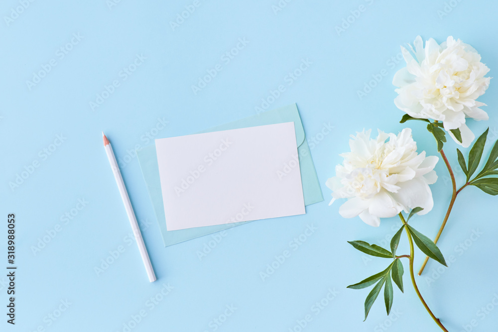 Mockup wedding invitation and envelope with white peonies on a blue background Mockup wedding invitation and envelope with white peonies on a blue background
