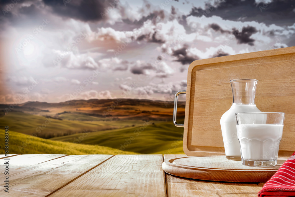 Fresh milk on wooden board and landscape of Tuscany 