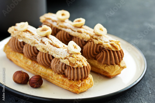 Homemade eclair with chocolate and nuts. Pastry.