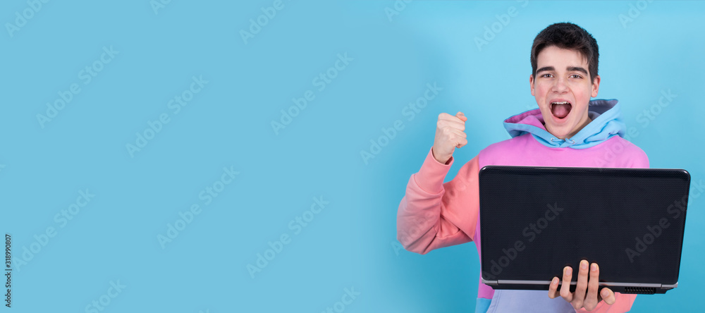 young teenage man or student with laptop isolated on background with surprise or success expression young teenage man or student with laptop isolated on background with surprise or success expression
