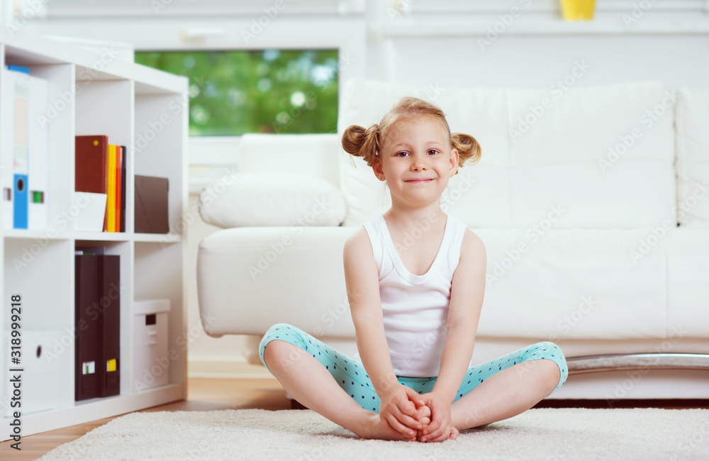 Cute little child girl making morning exercises at home Cute little child girl making morning exercises at home