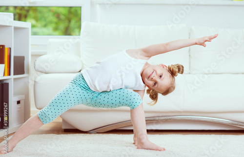 Принти на полотні Cute little child girl making morning exercises at home