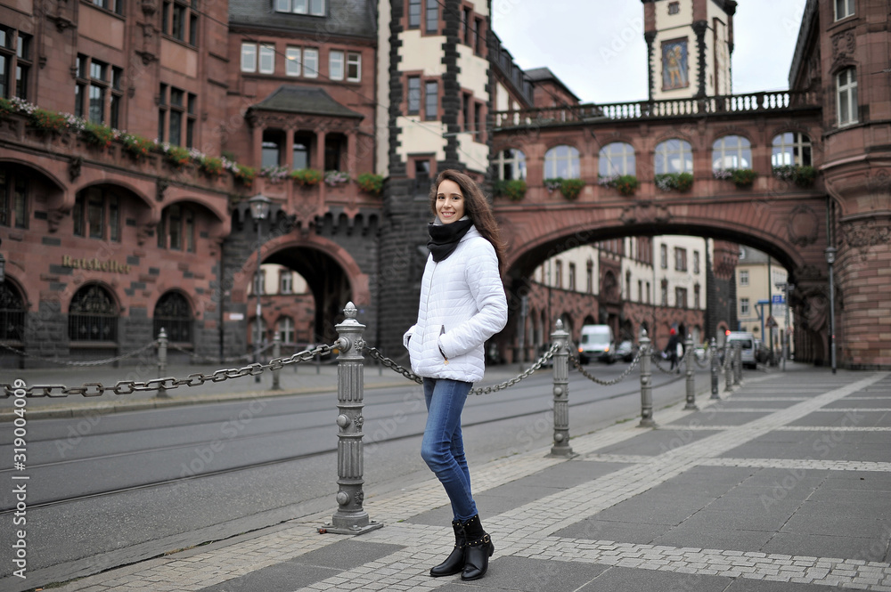 A tourist girl outdoors against the backdrop of the attractions of the city of Frankfurt am Main, Germany