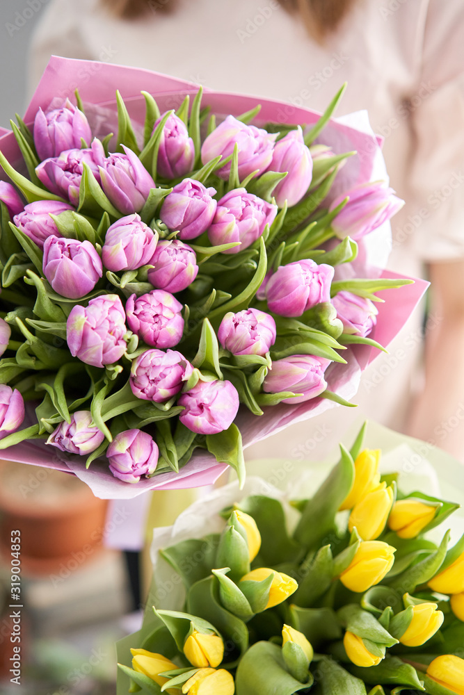 Two Beautiful bouquets of tulips in womans hands. the work of the florist at a flower shop. Delivery fresh cut flower. European floral shop.