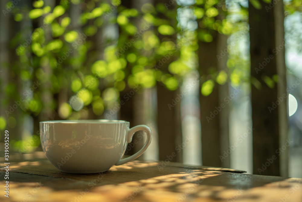 A cup of coffee on a wooden table in the morning. With copy space. and sunlight naturally a blurred background. A cup of coffee on a wooden table in the morning. With copy space. and sunlight naturally a blurred background.