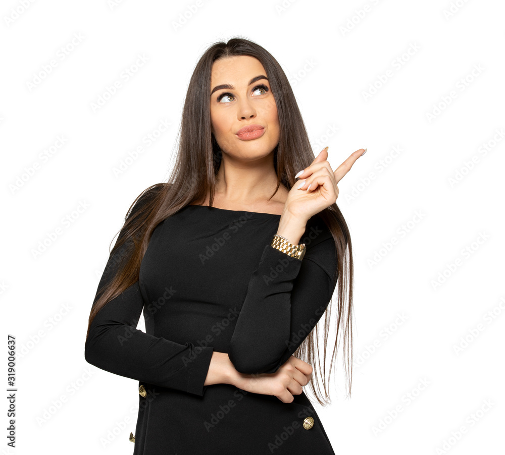 girl with dark hair points looks away and points with her finger. a young woman with dark hair and dark clothes on an isolated background in the Studio. the woman has large plump lips and long hair girl with dark hair points looks away and points with her finger. a young woman with dark hair and dark clothes on an isolated background in the Studio. the woman has large plump lips and long hair