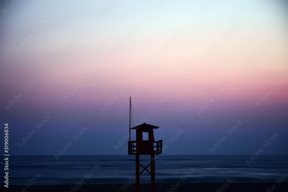 old wooden lifeguard house with sunset background old wooden lifeguard house with sunset background