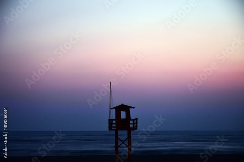old wooden lifeguard house with sunset background