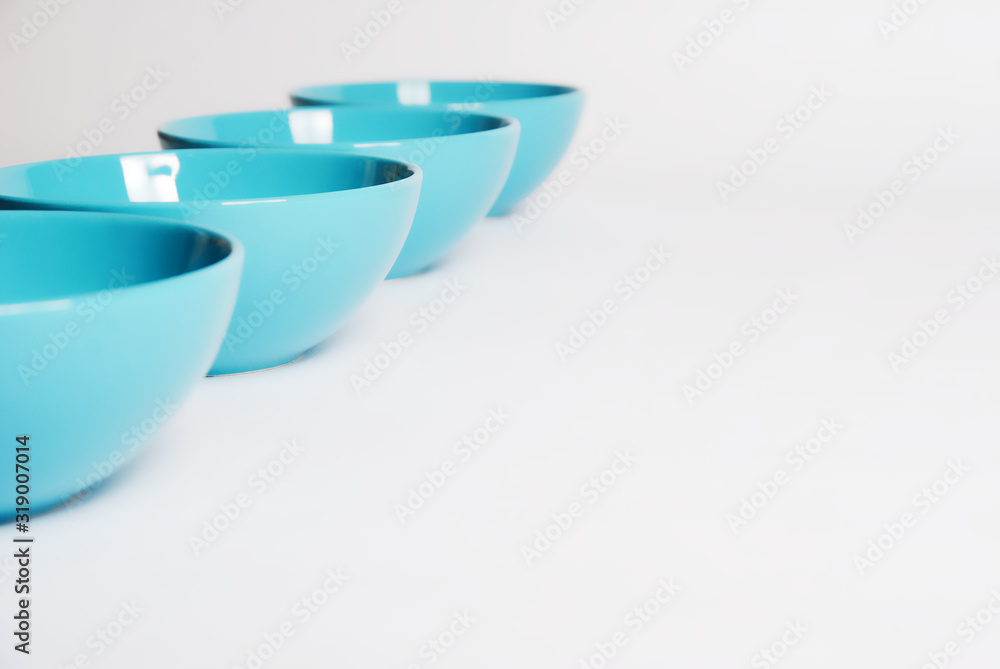 bright blue dishes in a row on a white background close up. nice clean bowl for soup bright blue dishes in a row on a white background close up. nice clean bowl for soup