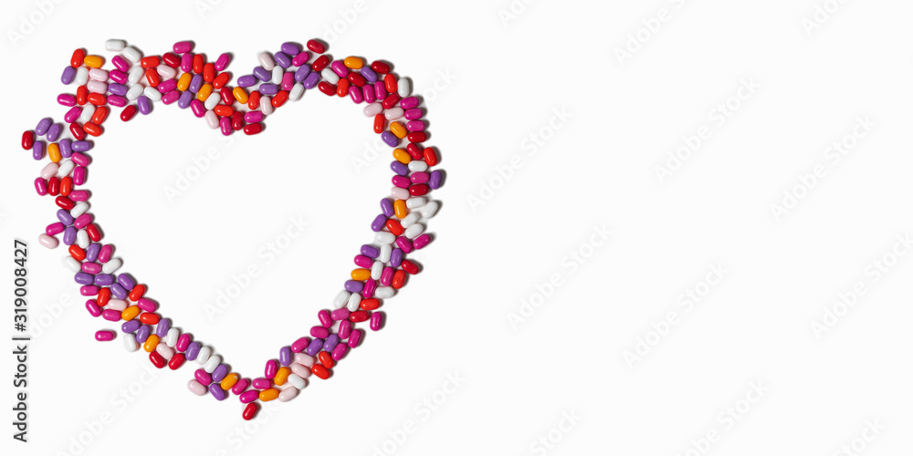 heart of colored pills on a white background. colored pills isolatred on white. empty space for text