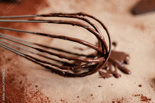 Process of preparation of delicious homemade dark chocolate. Whisk mixer, vintage copper tableware, ingredients on the table. Gourmet dessert. Close up, macro