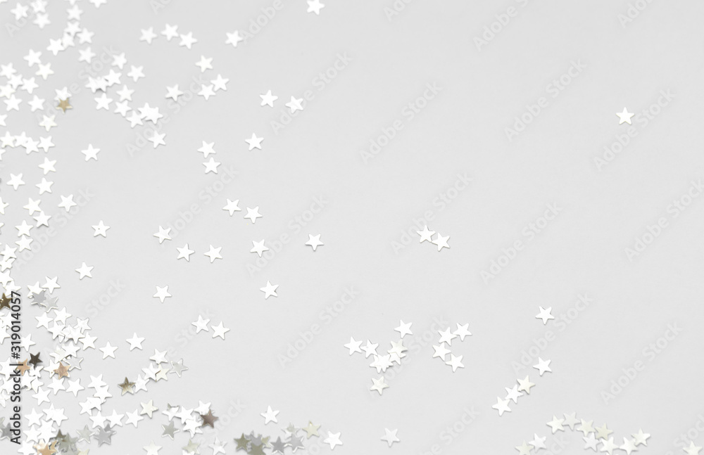 Silver confetti and stars and sparkles on a light background. Top view, flat lay. Copy text. holiday background. For Christmas, New Year, Valentine's Day Silver confetti and stars and sparkles on a light background. Top view, flat lay. Copy text. holiday background. For Christmas, New Year, Valentine's Day