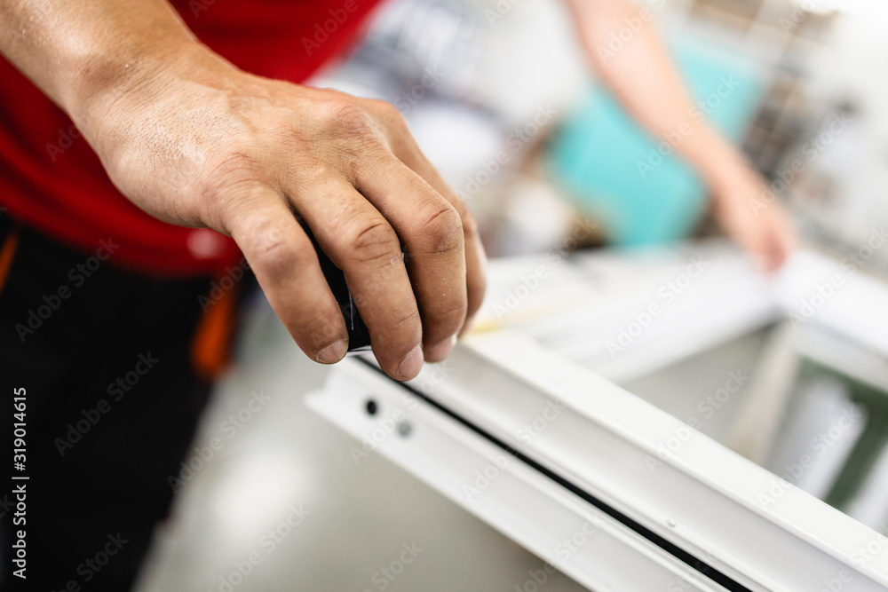 Manual worker assembling PVC doors and windows. Manufacturing jobs