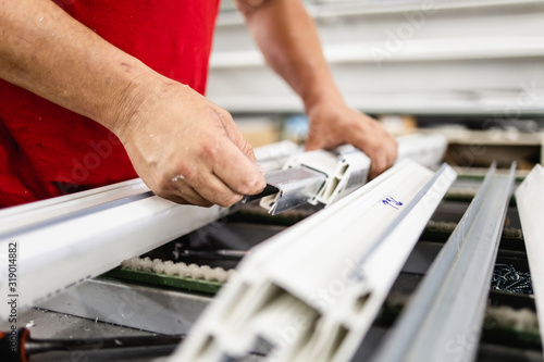 Manual worker assembling PVC doors and windows. Manufacturing jobs. Selective focus. Factory for aluminum and PVC windows and doors production.