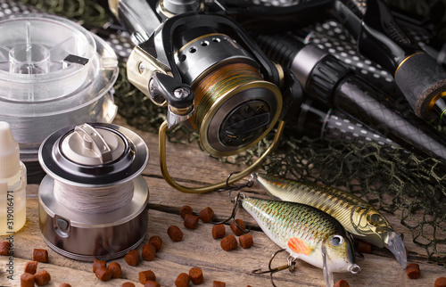 fishing tackle on a wooden table. toned image