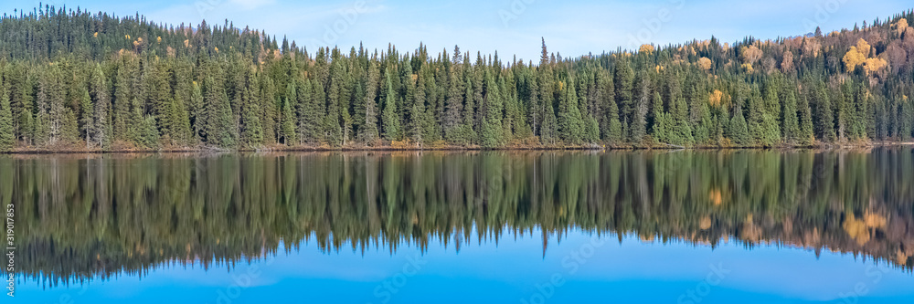 Canada, panorama of a mountain lake in the forest during the Indian summer, beautiful landscape in a wild country, reflection on the water