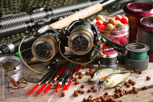 Fishing rods and spinnings in the composition with accessories for fishing on the old background on the table