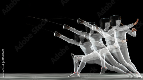 Foto Teen girl in fencing costume with sword in hand on black background in strobe light